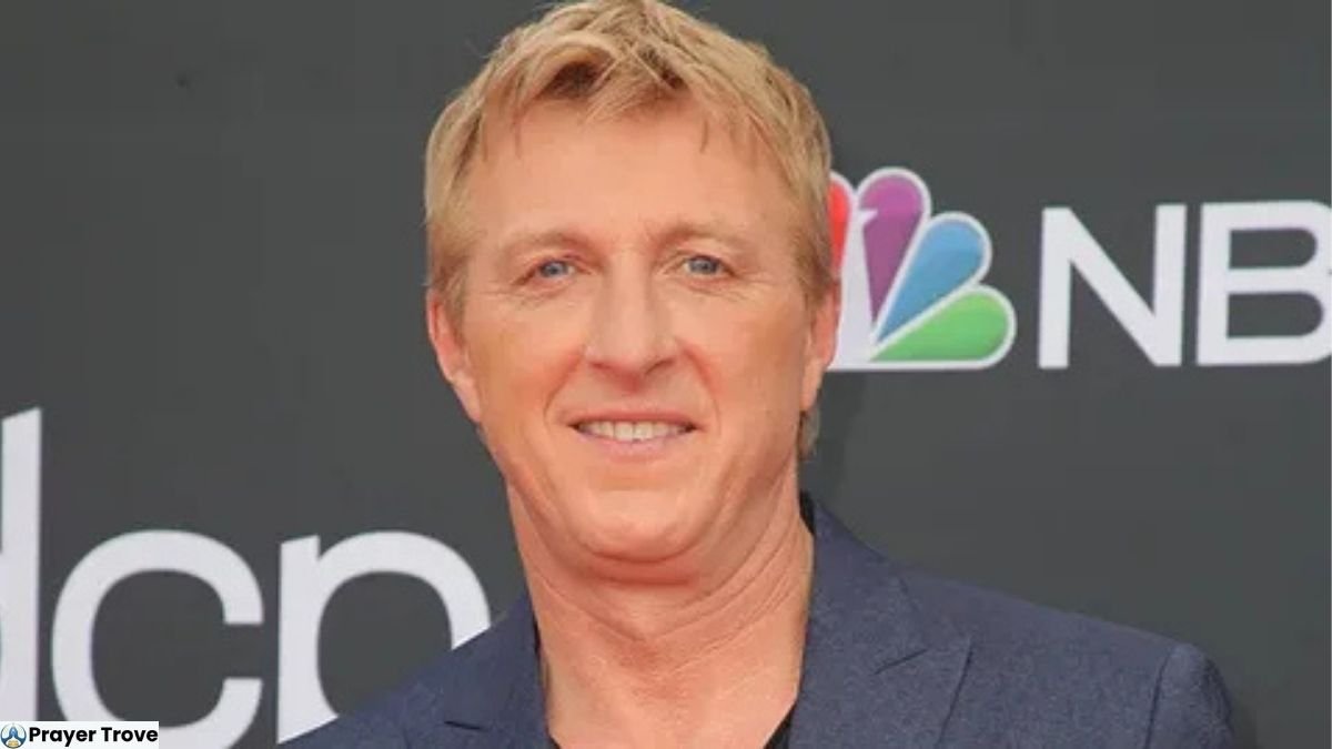 William Zabka smiling in a navy blue blazer